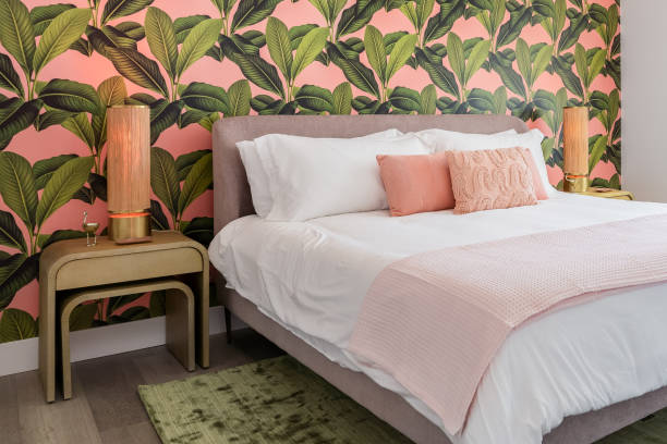 Bedroom with pink and green tropical wallpaper theme Bedroom with pink and green accent colors and tropical wallpaper theme pink bed stock pictures, royalty-free photos & images