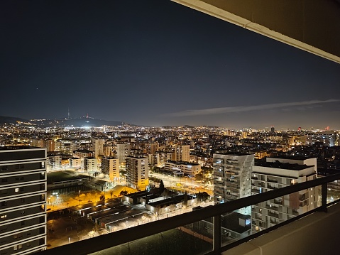 Night lights of Barcelona city including several blocks and Collserola mountain Tibidabo