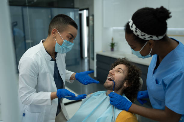 istock Female dentist and an intern communicating with a patient 2061224699