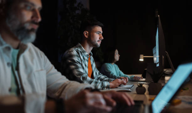 istock Attractive and clever young caucasian man wearing stylish shirt using pc computer in cozy evening office 2061224882