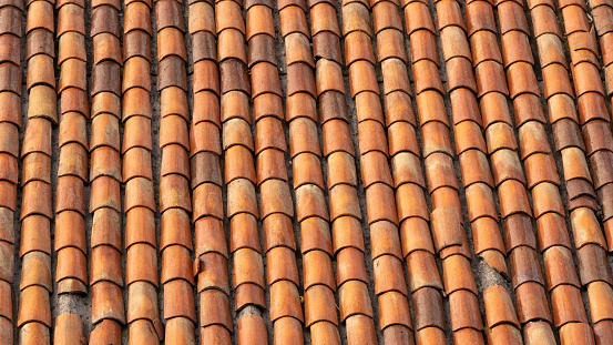 Background of old roof tiles. Roofing texture. Red corrugated tile element of roof. Seamless pattern.