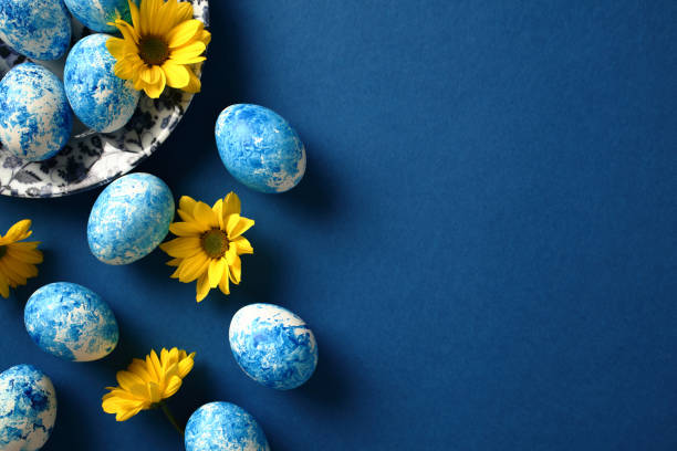 istock Happy Easter greeting card. Colorful Easter eggs with yellow flowers on dark blue background. 2061234293