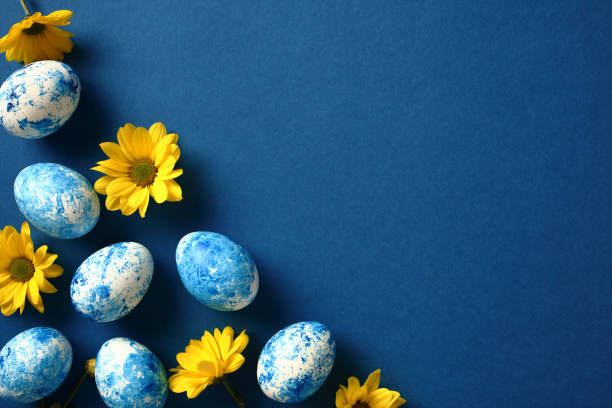 istock Happy Easter greeting card with painted eggs and yellow flowers on dark blue background. Top view, flat lay, copy space. 2061237929