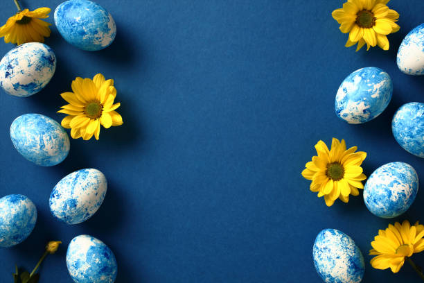 istock Happy Easter greeting card. Blue Easter eggs with yellow flowers on dark blue background. Flat lay, top view, copy space. 2061238462