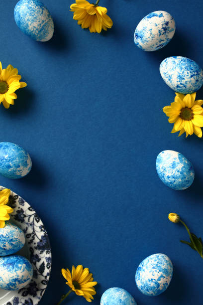 istock Happy Easter vertical banner. Frame made of colorful Easter eggs and yellow flowers on dark blue background. 2061242123