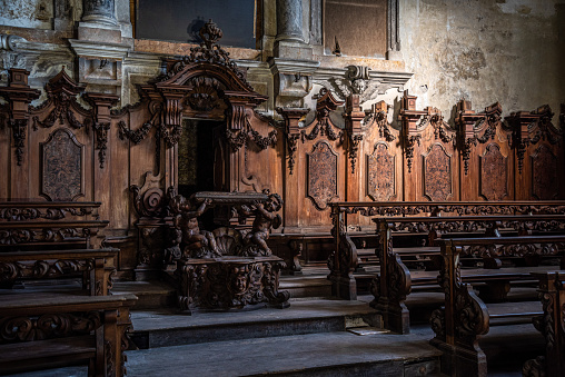 Beautiful wooden decoration, benches and a pupit in the abandoned church Santo Siro e Libera in Verona, Italy