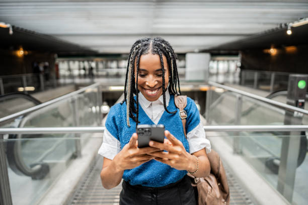 istock Young woman using mobile phone at subway station 2061251627