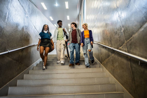 istock Young friends moving down staircases at subway station 2061256320