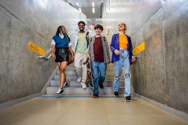 istock Young friends moving down staircases at subway station 2061256331