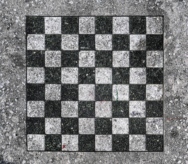 chessboard on a stone table in a public park (brooklyn new york city) chess board checkered squares pattern close up detail black and white game outdoors