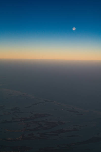 Photograph of a clear evening sky, just after sunset, with a smooth gradient from black down to golden yellow/orange.