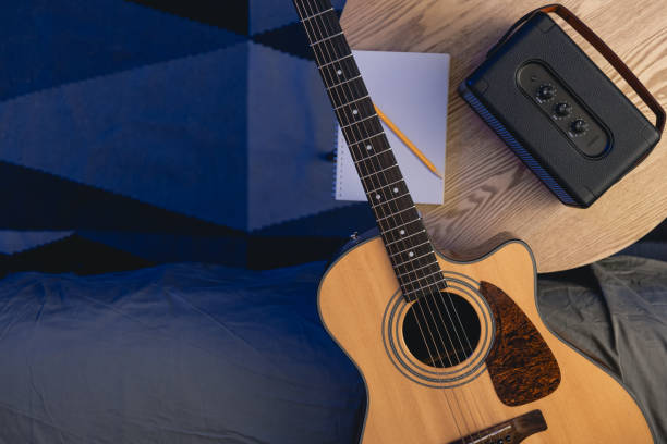 istock Musical background with acoustic guitar, speaker and notepad on the table. 2061294778
