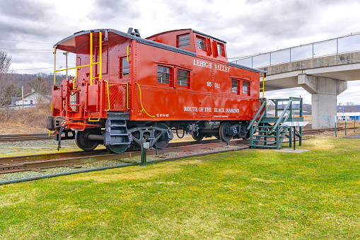 Sayre, PA, USA - 03-03-2024 - Restored red vintage caboose at the Sayre Historical Society Museum at Lehigh Valley Railroad Passenger Station.