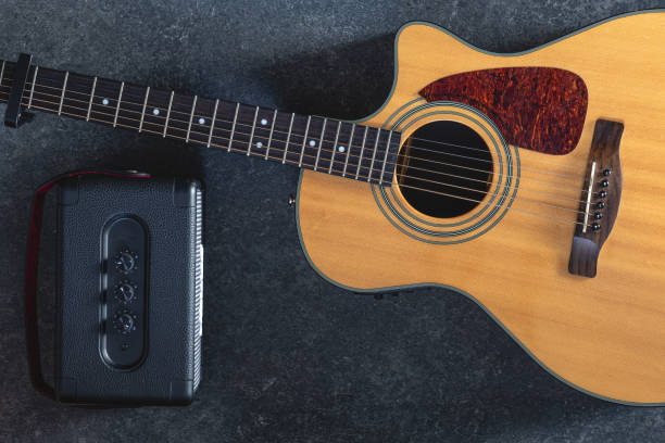 istock Acoustic guitar and speaker on black background, top view. 2061297213