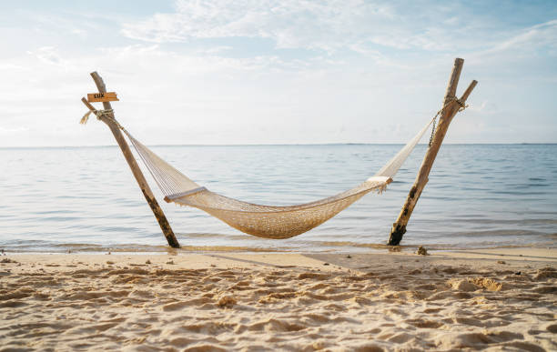 Hammock net installed on the shallow sandy daytime beach on Le Morne peninsula, Mauritius. Calm sunset time beautiful vacation photo..