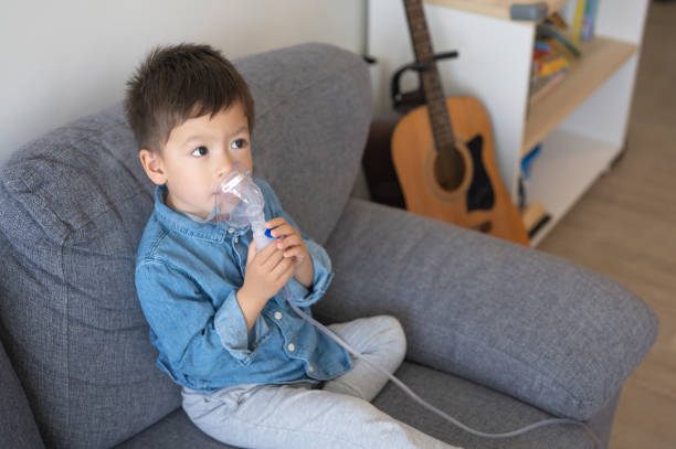 niño pequeño usando un nebulizador de inhalación en casa - tubing child oxygen mask medical oxygen equipment fotografías e imágenes de stock