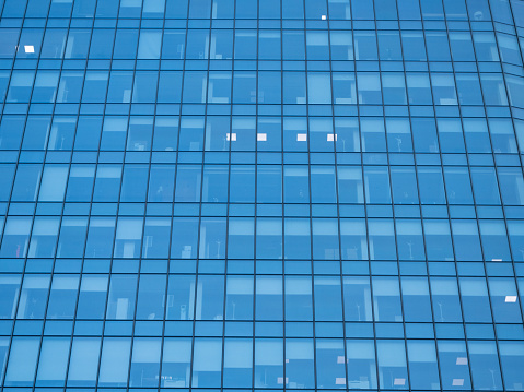 Closeup glass wall of office building with reflection of city, background with copy space, full frame horizontal composition