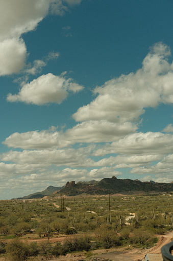 Arizona desert countryside with mountains and clouds in the distance and cactus. No people