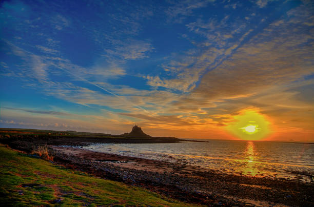 на остров линдисфарн приходит рассвет. - lindisfarne стоковые фото и изображения