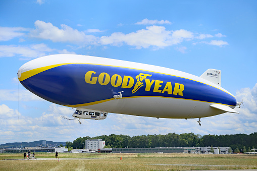 blimp flying in clear blue sky with blue copy space to advertise your message