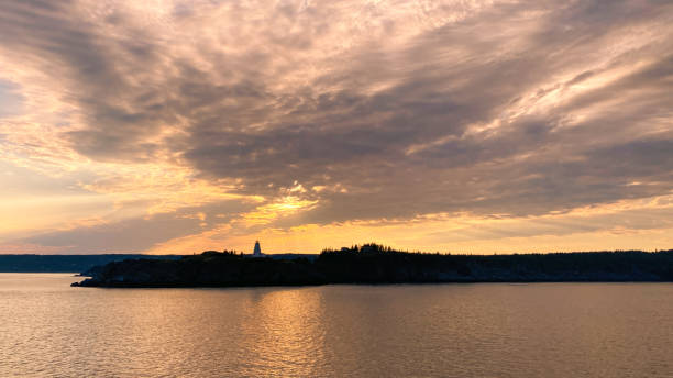 céu laranja do pôr do sol sobre a ilha com farol - grand manan island - fotografias e filmes do acervo