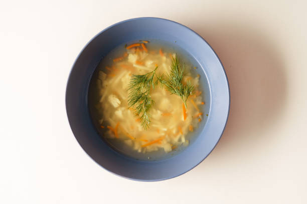 istock Chicken soup in a plate over light pink background. 2061413148