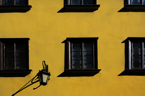 Exterior background, beautiful yellow wall building with windows and shadows in the Old town (Stare Miasto) of Warsaw, capital of Poland