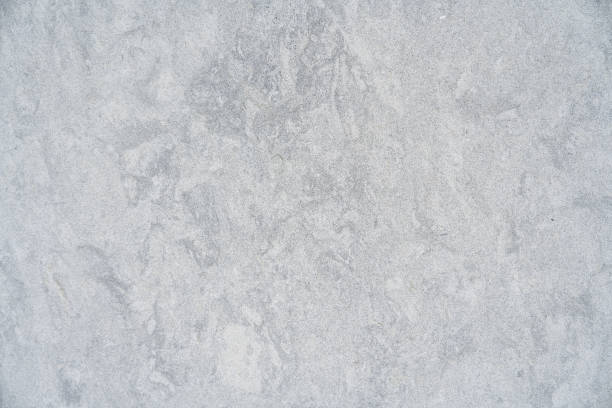 Sleek grey surface appearing to be of concrete or stone. Upside characterized by irregular texture and patterns. Concept of wallpapers and wall coverings. High quality photo