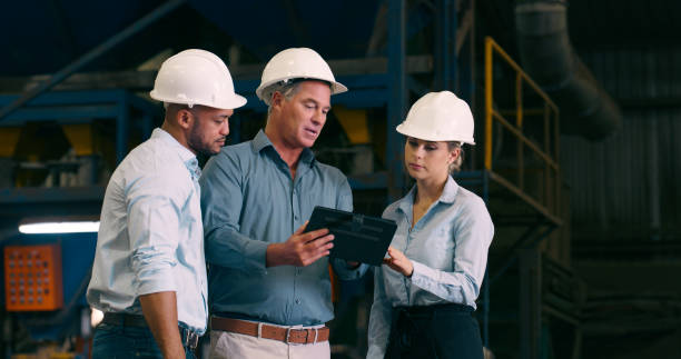 istock Teamwork, men and woman in factory with tablet for planning, development and machine manufacturing. Inspection, contractor and project manager talking in plant with online digital app for maintenance 2061480449