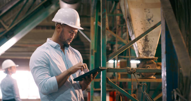 istock Tablet, helmet and man with engineering, typing and inspection with online software and digital app. Manufacturing, architect or employee with tech or industrial with construction project or hard hat 2061481024