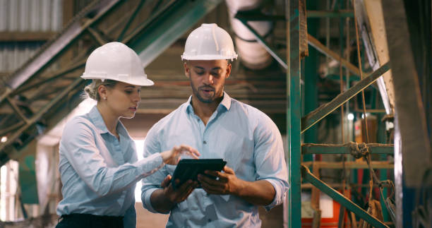istock Business people, inspection and tablet for electrical engineering, maintenance and planning in workshop. Staff, manager or employee with tech or internet with industry or contractor with productivity 2061481026