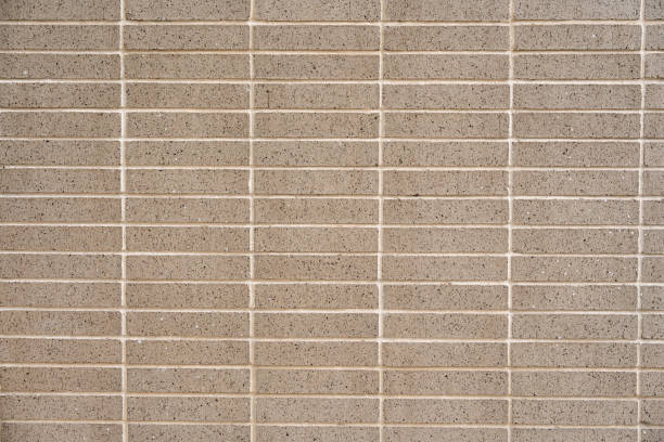 istock Wall covered with beige symmetrical and minimalistic tiles. Square and smooth material separated by light-colored grout lines. Concept of texture and pattern 2061484784