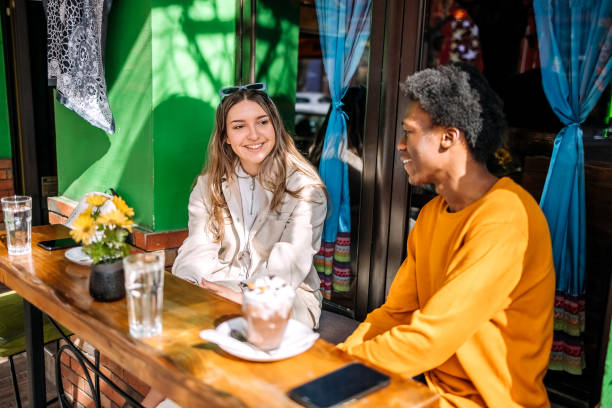 istock Two young adults having coffee together talking outside of cafe 2061486881