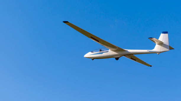 White glider plane against the blue sky.