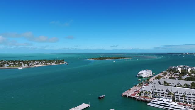 Scenic beauty of Key West, Southernmost Point of Continental USA. Blue ocean with boats moored and floating peacefully. Coastline with luxury buildings. Concept of wealthy