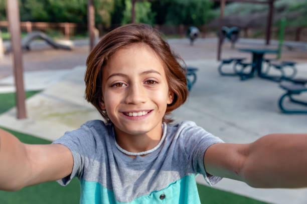 istock Portrait of surfer kid smiling taking selfie 2061523937