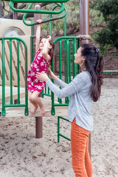 istock Young girl playing on monkey bars in a park 2061527113