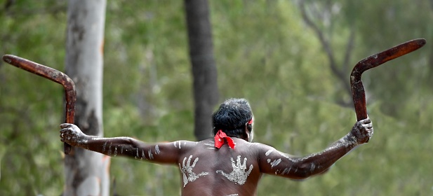 Laura, Qld - July  08 2023:Indigenous Australians man holding boomerang on ceremonial dance in Laura Festival Cape York Australia. Ceremonies combine dance, song, rituals, body decorations and costume.