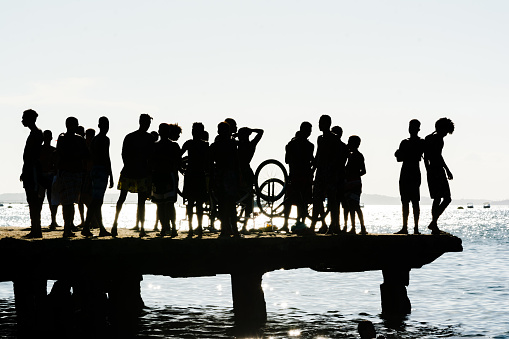 Salvador, Bahia, Brazil - March 09, 2019: Dozens of young people, in silhouette, are seen during the sunset on top of the Crush bridge in the city of Salvador, Bahia.