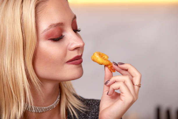 istock A woman with her hands eats a large appetizing shrimp. Selective focus. 2061615461