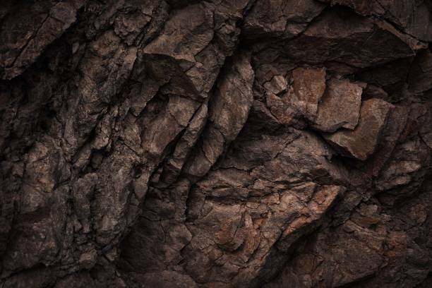 fond de texture de basalte de pierre de roche de granit de roche brun foncé noir. surface des montagnes. gros plan. fissuré, cassé, émietté. - surface mine photos et images de collection