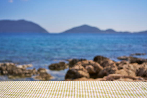 istock Empty wooden table with tablecloth over summertime seaside background 2061688152