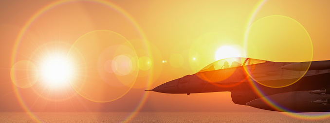 Solo fighter jet captured mid-flight with a dramatic sunset and intense lens flare.
