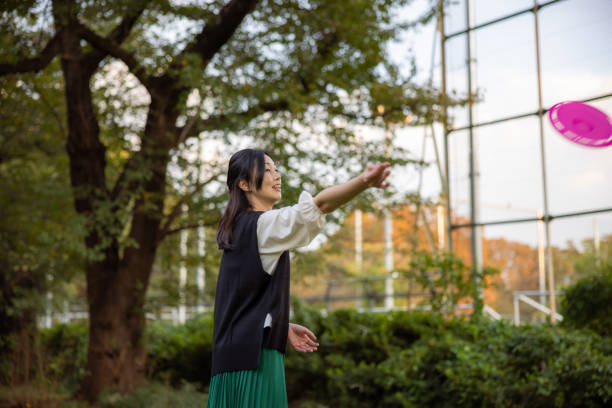 istock Woman throwing disc in public park 2061739171