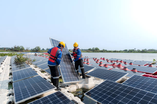 istock Male workers repair Floating solar panels on water lake. Engineers construct on site Floating solar panels at sun light. clean energy for future living. Industrial Renewable energy of green power. 2061756325
