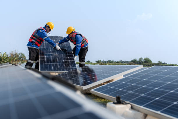 istock Male workers repair Floating solar panels on water lake. Engineers construct on site Floating solar panels at sun light. clean energy for future living. Industrial Renewable energy of green power. 2061763385