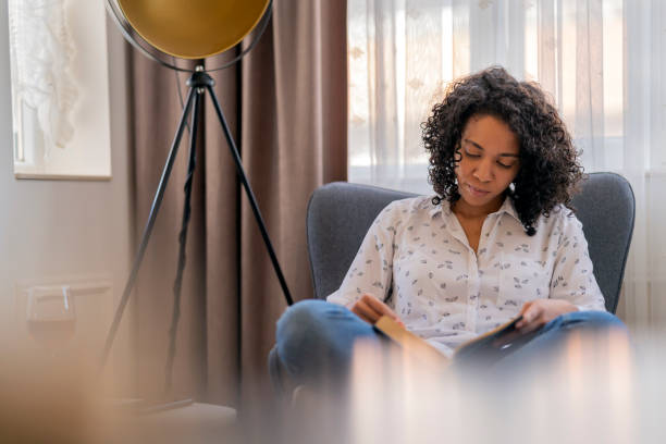 istock Young African American woman sitting reading a book 2061765799