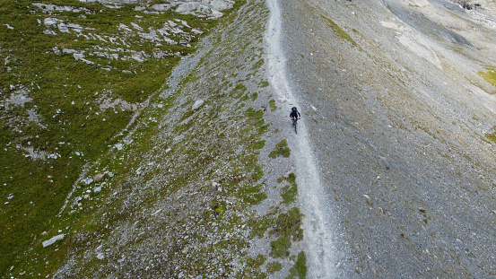 Aerial view of mountain biker on mountain ridge, Swiss Alps