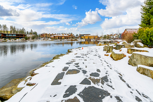 Riverstone public park and lake during winter with snow on the ground, in the Riverstone commercial and residential development in downtown Coeur d'Alene, Idaho.