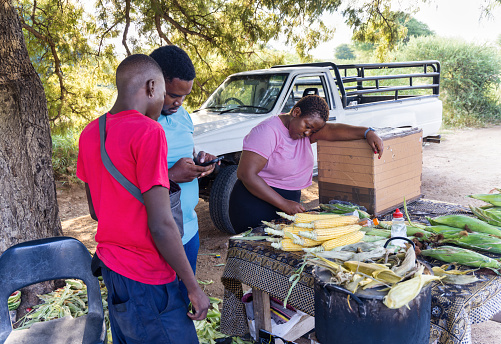 african street vendor selling boiled sweetcorn on the side of the road